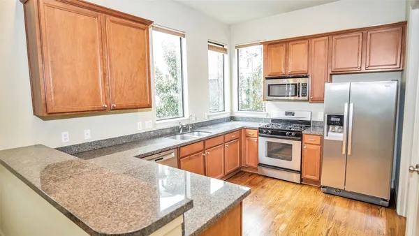 a kitchen with stainless steel appliances granite countertop a stove a sink and a refrigerator