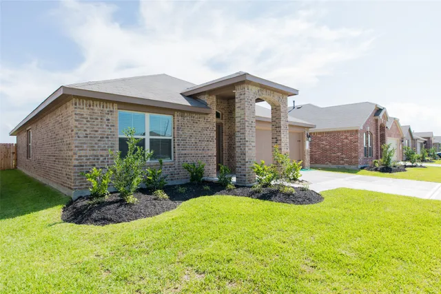 a front view of a house with a yard and potted plants