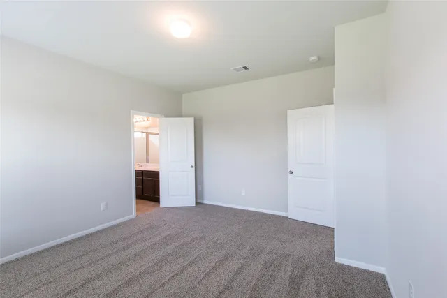 a view of an empty room with wooden floor and closet