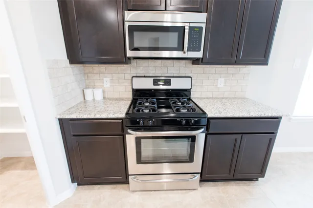 a kitchen with granite countertop cabinets and steel stainless steel appliances