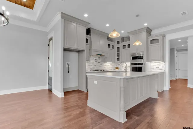 a kitchen with stainless steel appliances kitchen island granite countertop a refrigerator and a sink