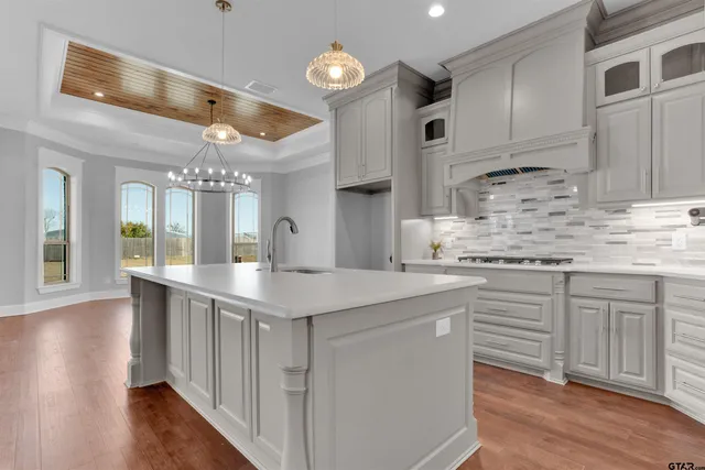 a kitchen with stainless steel appliances granite countertop a lot of counter space and wooden floors