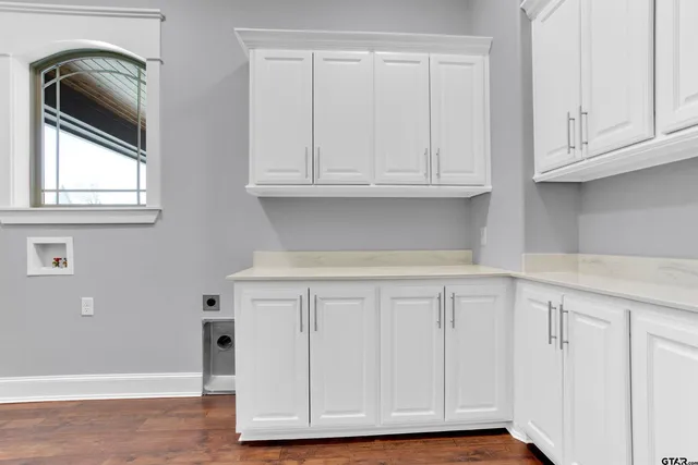 a close view of a kitchen with granite countertop white cabinets and a wooden floor