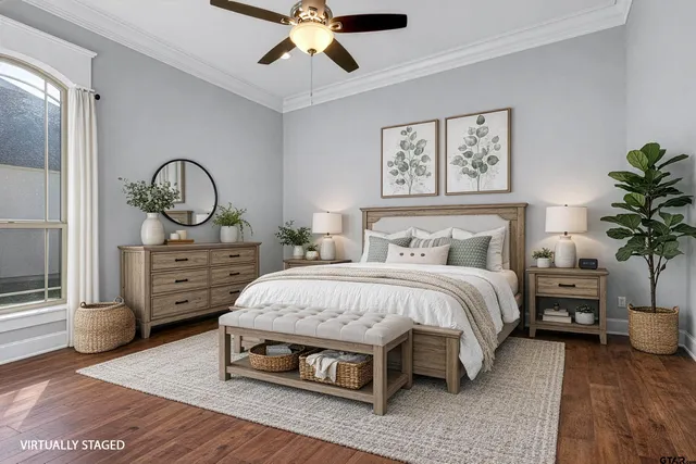 a spacious bedroom with a bed and a potted plant on the dresser