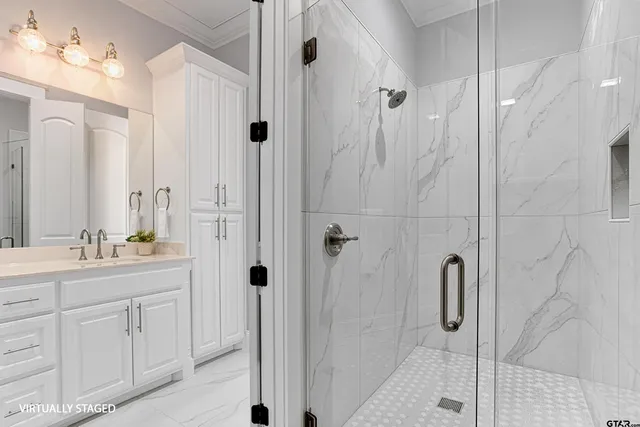 a bathroom with a double vanity sink a mirror a glass door a shower and a glass door