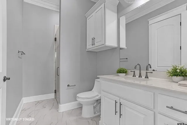 a bathroom with a granite countertop toilet sink and mirror