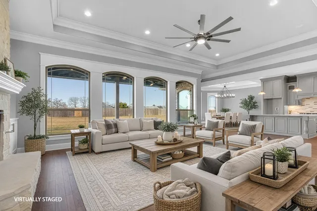 a living room with furniture ceiling fan and a large window