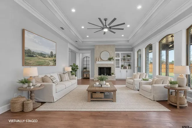 a living room with furniture a fireplace and a large window