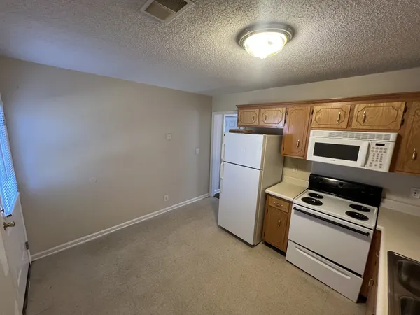 a kitchen with refrigerator and microwave