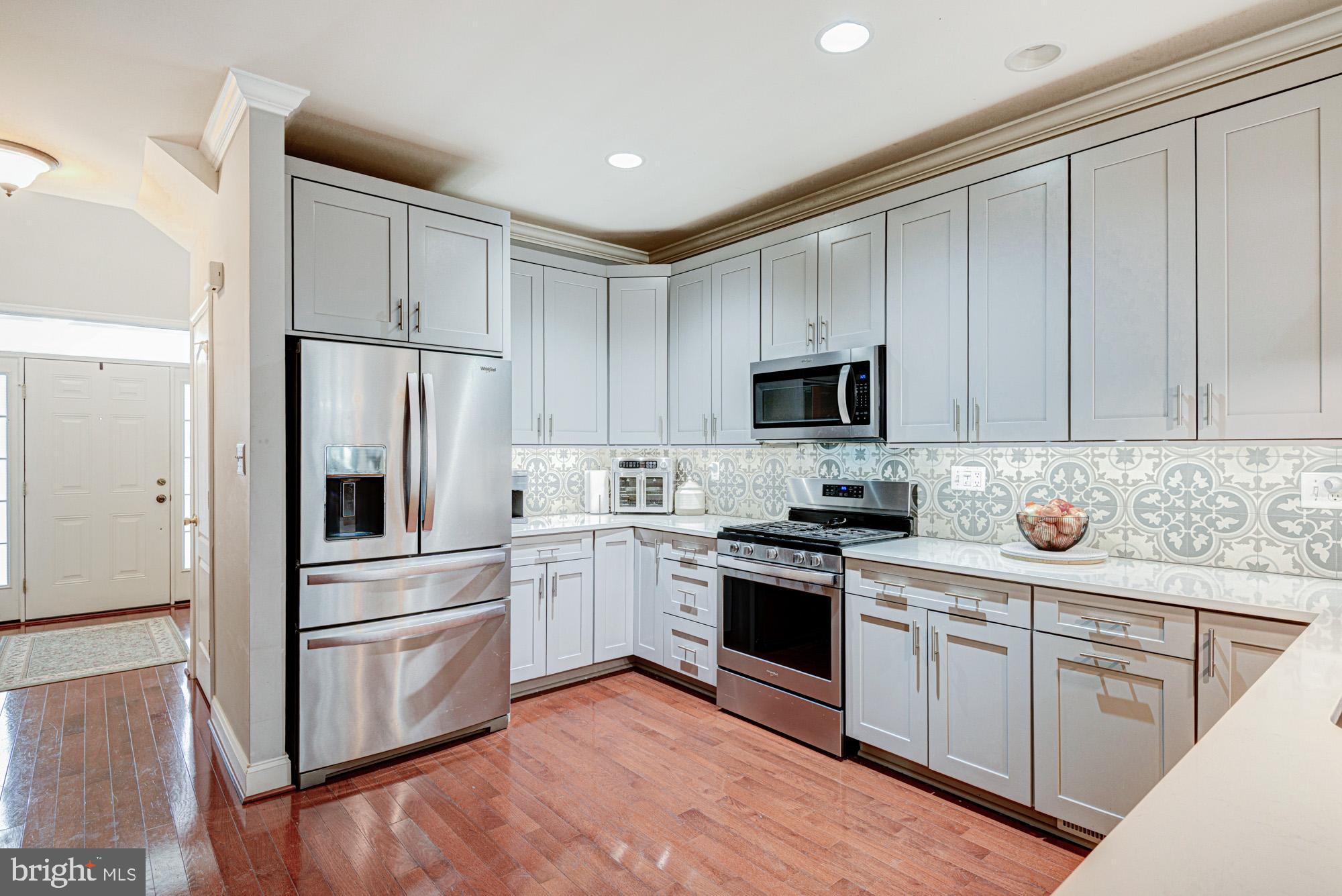 a kitchen with white cabinets and stainless steel appliances