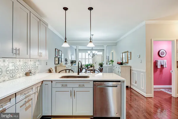 a kitchen with stainless steel appliances granite countertop a sink a island with cabinets and wooden floor
