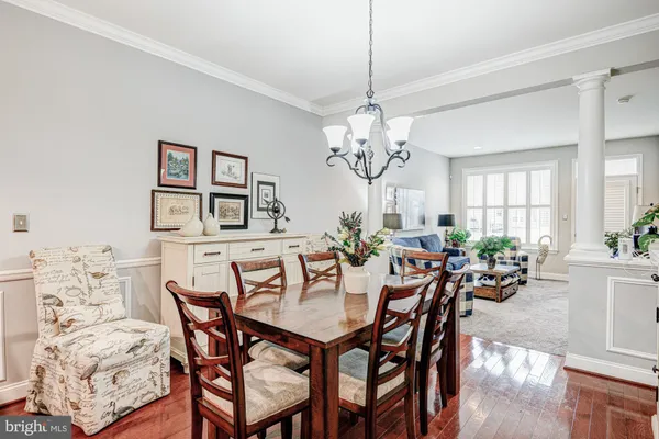 a view of a dining room with furniture a chandelier and wooden floor