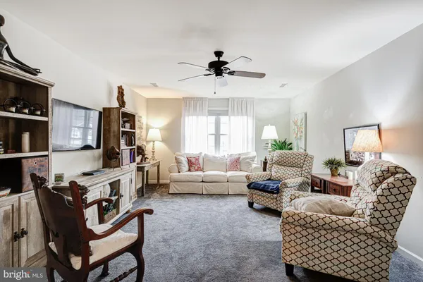 a living room with furniture ceiling fan and a window