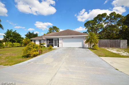 28 Michigan Road Lehigh Acres, FL 33936 - Photo 1 of 20 a front view of a house with a yard and potted plants