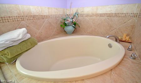 28 Michigan Road Lehigh Acres, FL 33936 - Photo 11 of 20 a white bath tub sitting in a bathroom
