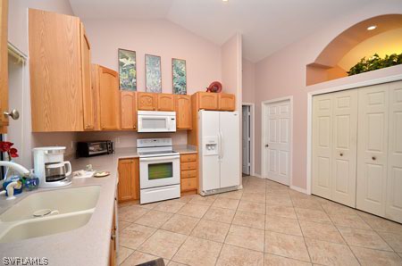 28 Michigan Road Lehigh Acres, FL 33936 - Photo 7 of 20 a kitchen with stainless steel appliances a stove a sink and a refrigerator