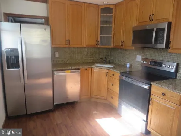 a kitchen with stainless steel appliances granite countertop a refrigerator and a microwave