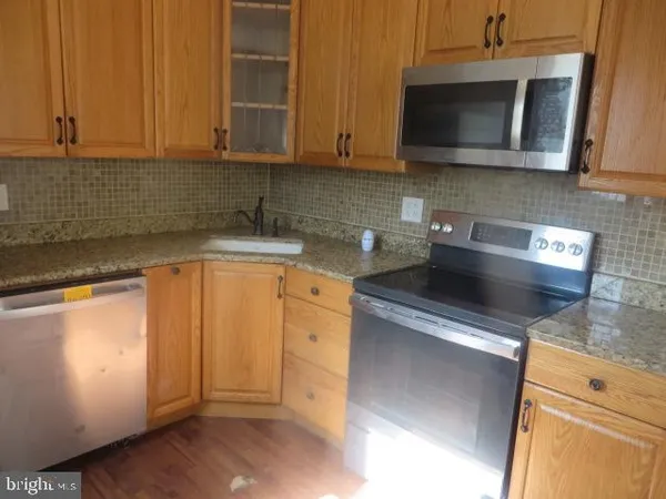 a kitchen with stainless steel appliances granite countertop a sink stove and microwave