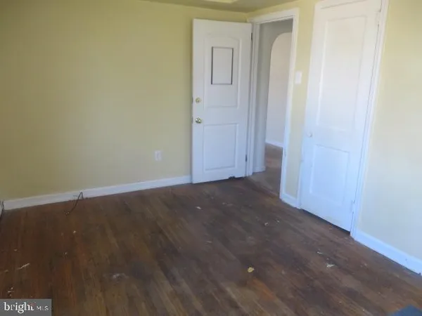 an empty room with wooden floor and closet