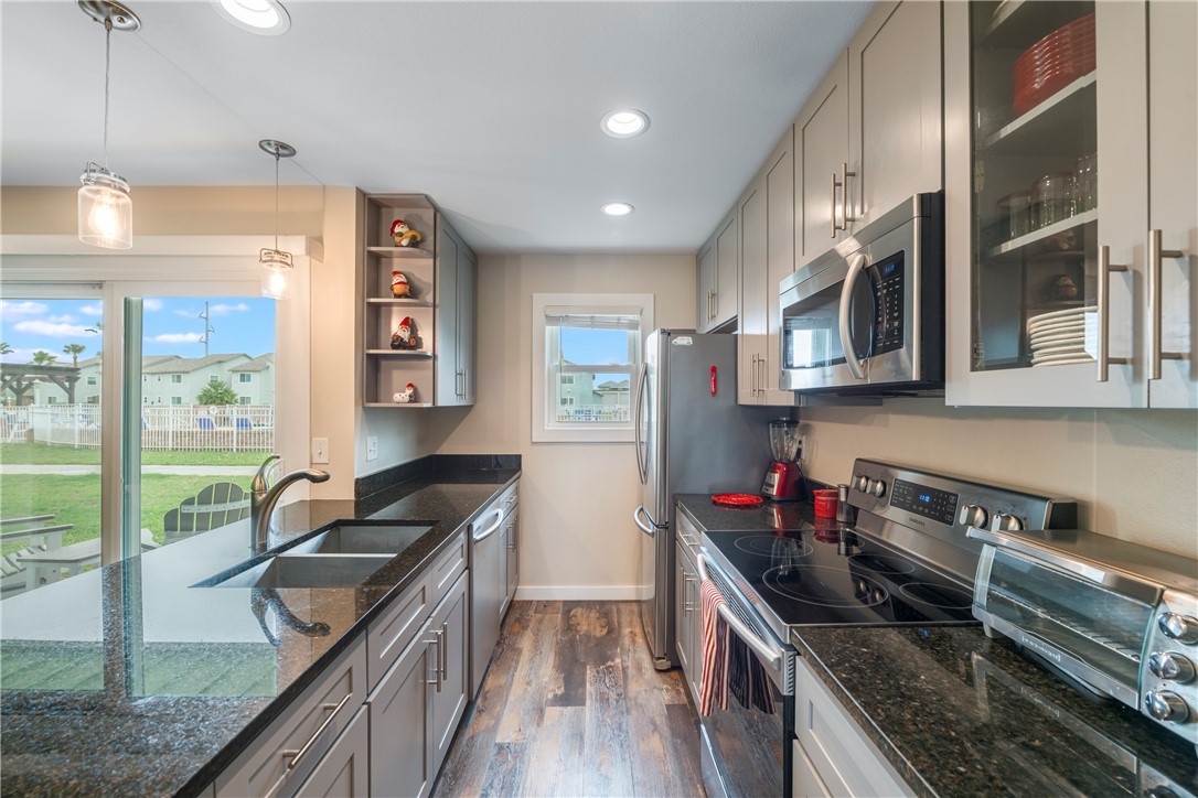 230 Cut-Off Road, Unit 101 Port Aransas, TX 78373 - Photo 10 of 30 a kitchen with stainless steel appliances granite countertop a sink stove and refrigerator