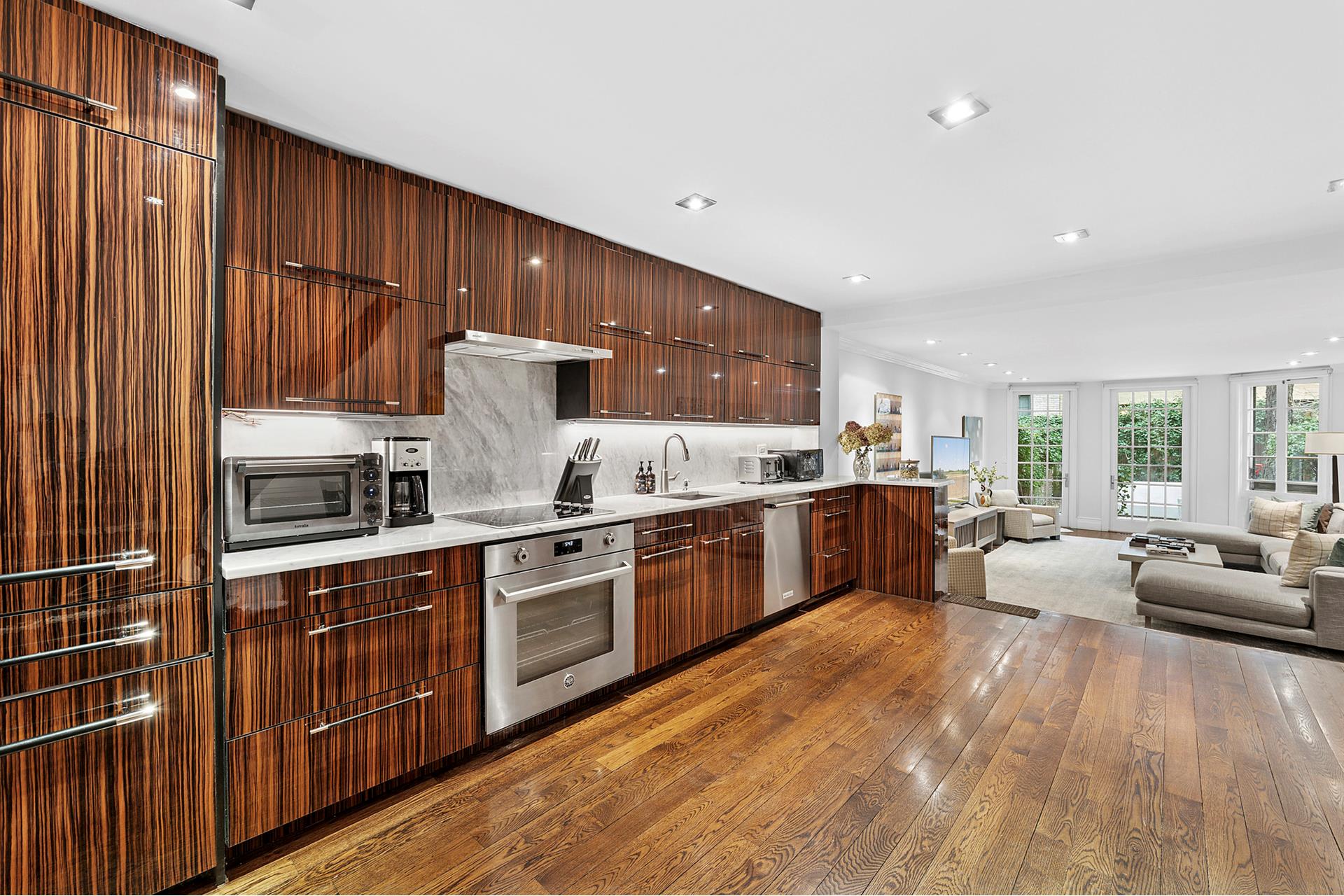 165 East 71st Street Manhattan, NY 10021 - Photo 3 of 12 a kitchen with stainless steel appliances granite countertop a stove top oven sink and cabinets