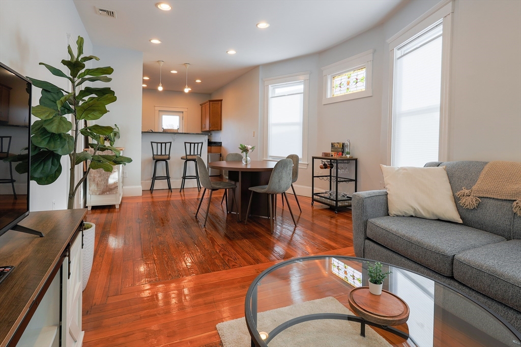 7 Treadway Road, Unit 3 Boston, MA 02125 - Photo 1 of 1 a living room with furniture and a dining table with wooden floor