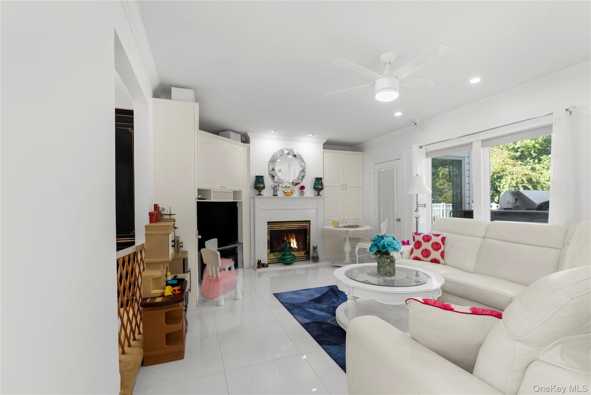 28 Annandale Road Commack, NY 11725 - Photo 8 of 29 Living room featuring a warm lit fireplace, light tile patterned floors, a ceiling fan, and recessed lighting