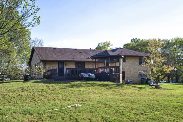 a view of swimming pool with seating area and trees in the background