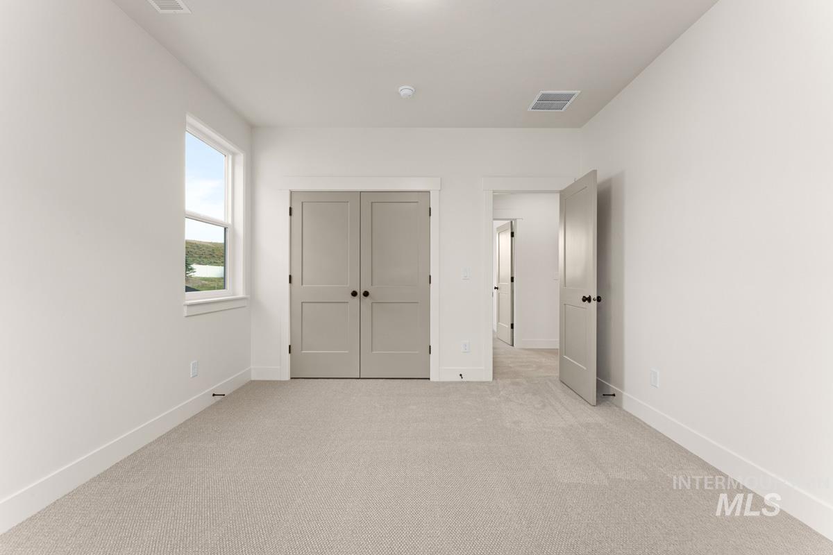 13338 North Spring Creek Way Boise, ID 83714 - Photo 25 of 46 Spacious room featuring light-toned carpeting, white walls, and a double-hung window with a white frame