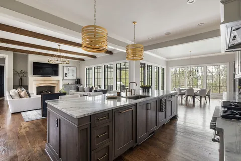 a kitchen with a counter space a sink appliances and living room view