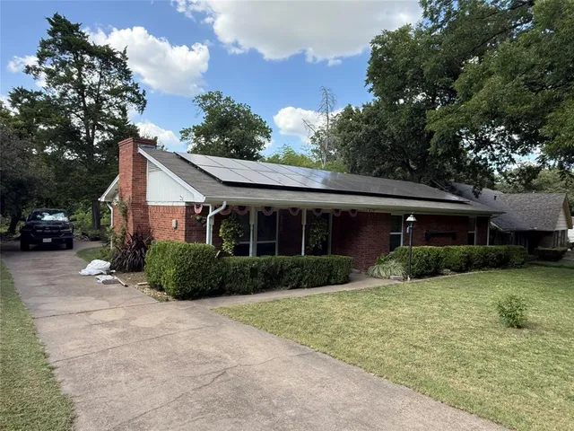 a view of a house with a yard and potted plants