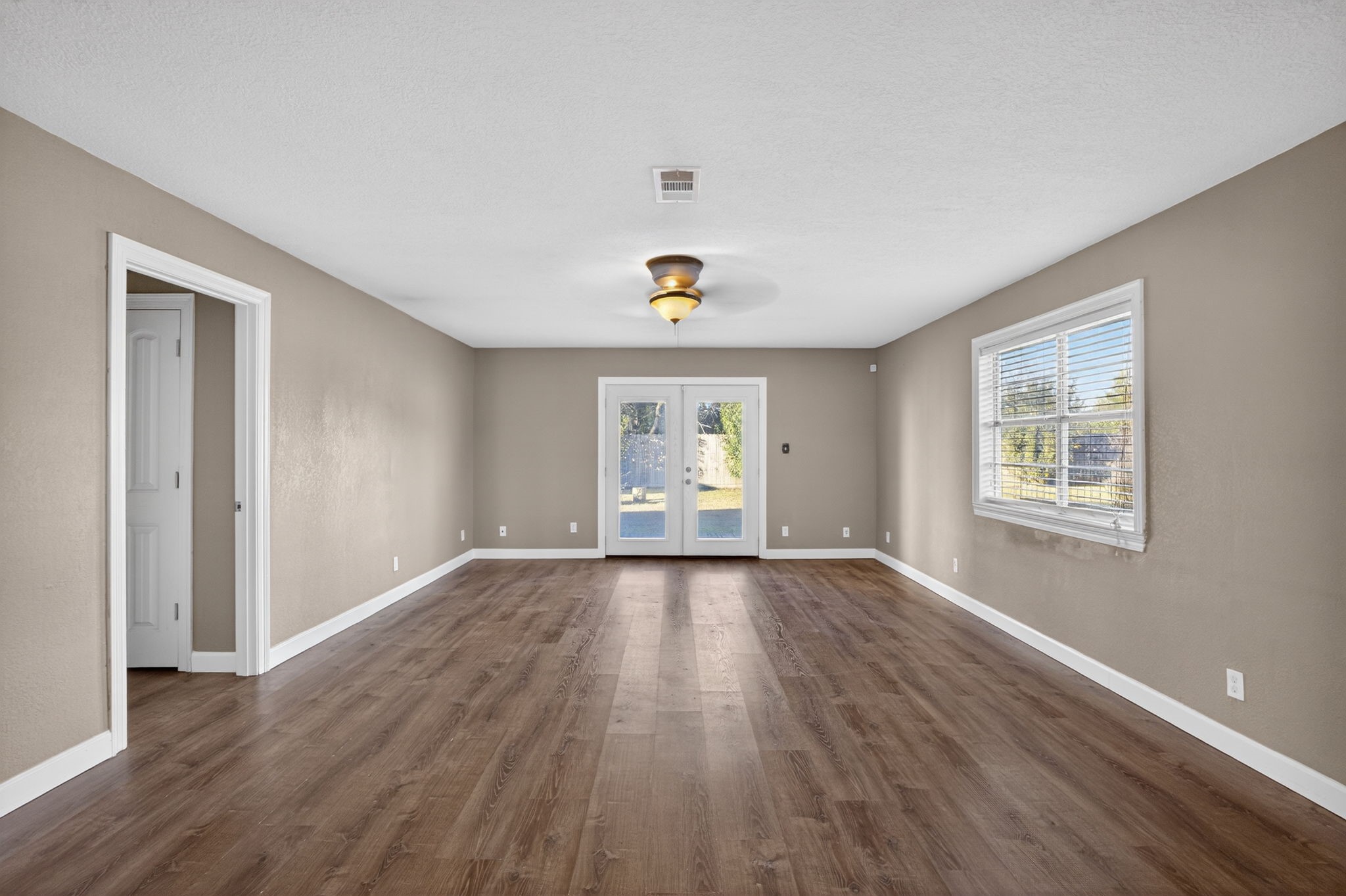 255 Gilmer Street Bridge City, TX 77611 - Photo 17 of 37 an empty room with wooden floor and windows