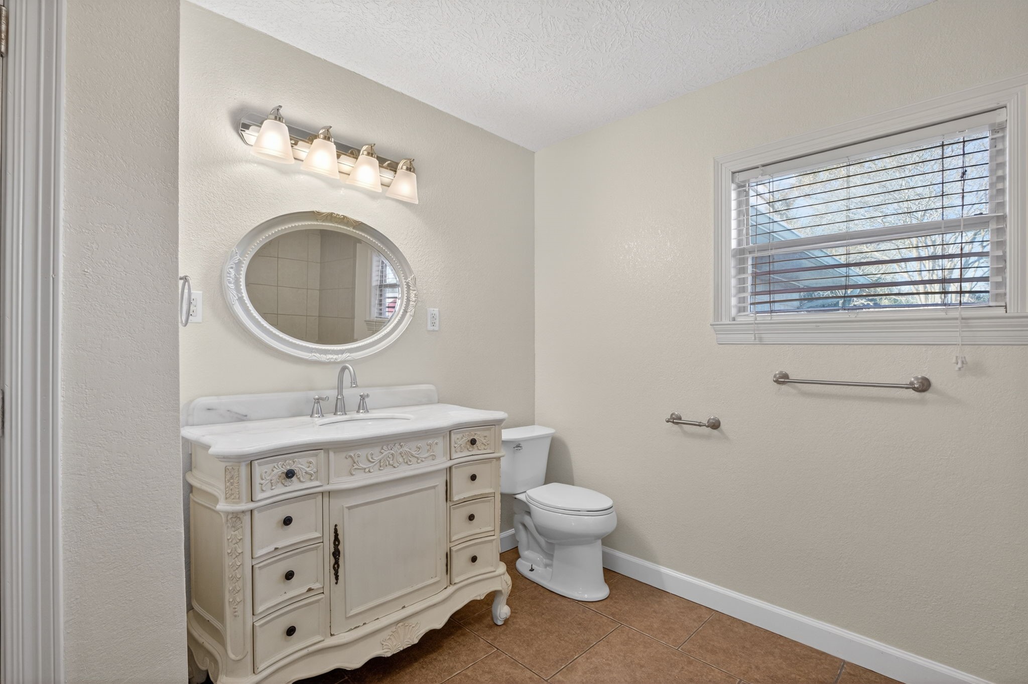255 Gilmer Street Bridge City, TX 77611 - Photo 28 of 37 a bathroom with a toilet a sink and a mirror