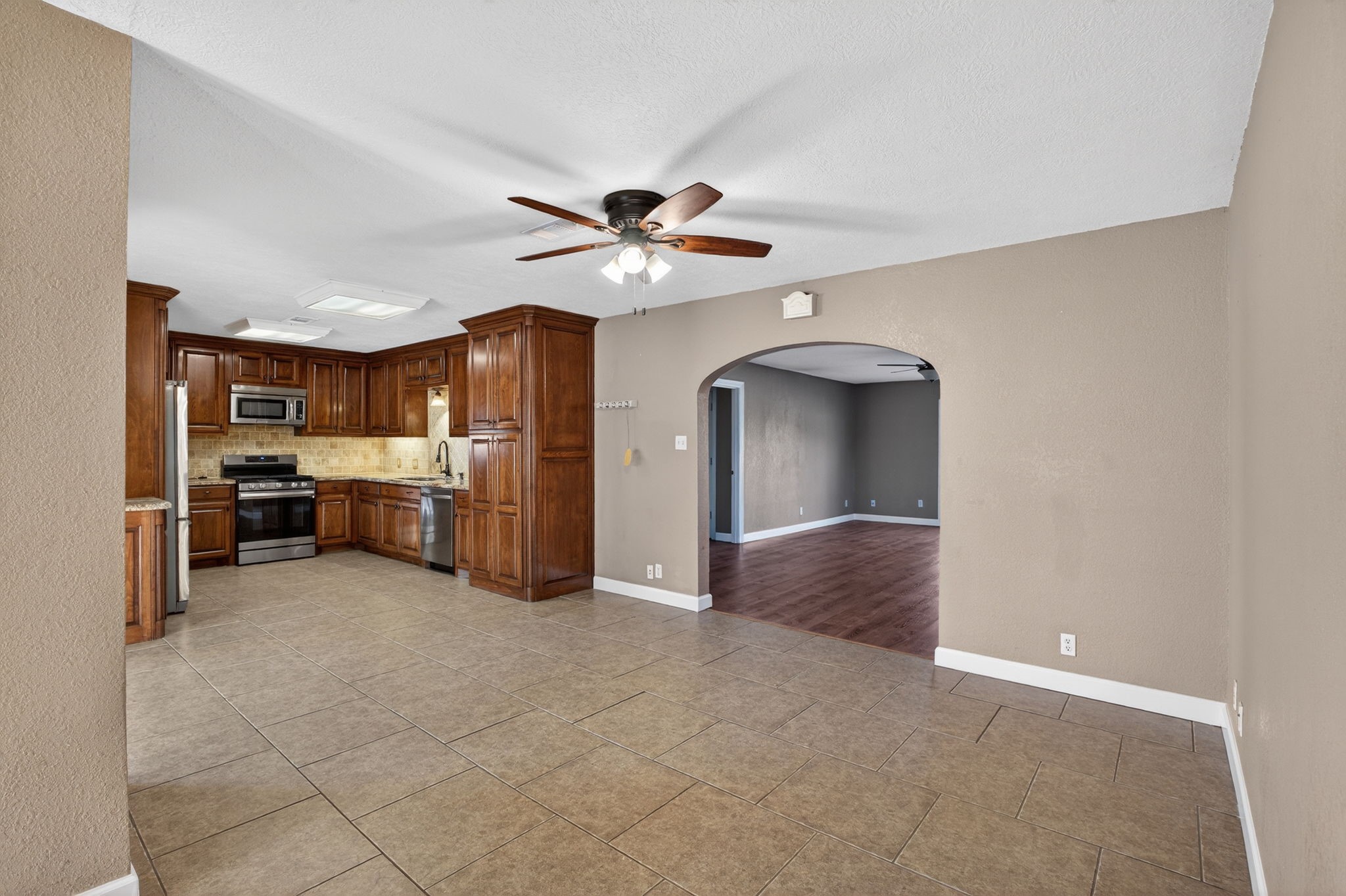 255 Gilmer Street Bridge City, TX 77611 - Photo 9 of 37 a view of a kitchen with furniture and a ceiling fan