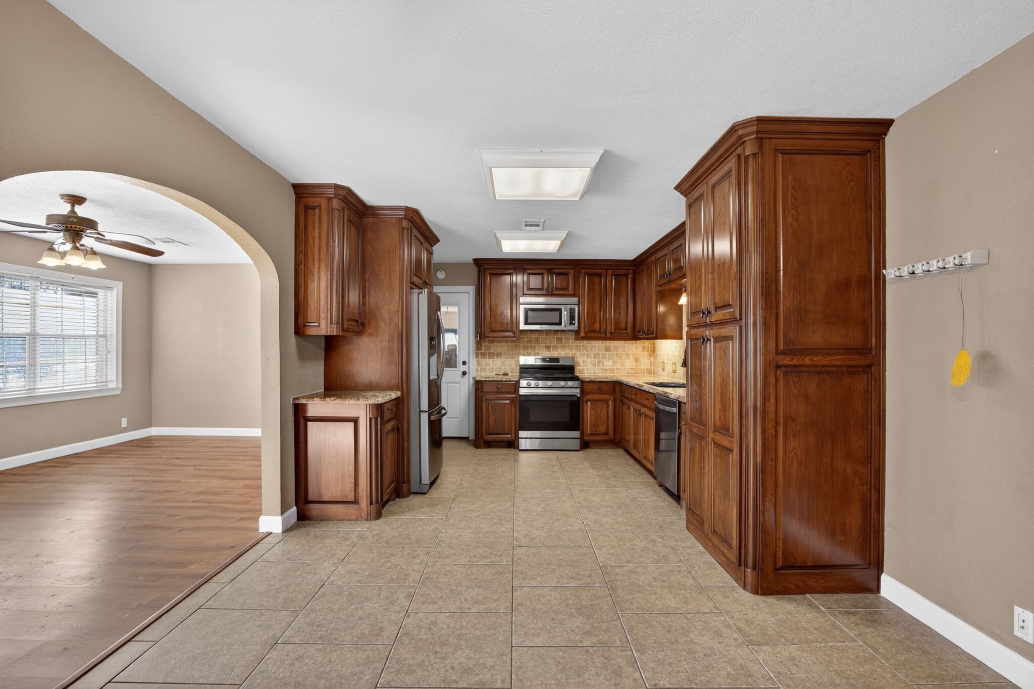 255 Gilmer Street Bridge City, TX 77611 - Photo 10 of 37 a kitchen with granite countertop a refrigerator and a sink