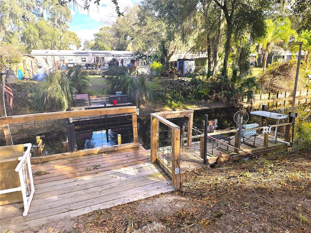 2121 Southeast 170th Avenue Road Silver Springs, FL 34488 - Photo 1 of 23 a view of a patio with table and chairs with wooden floor and fence