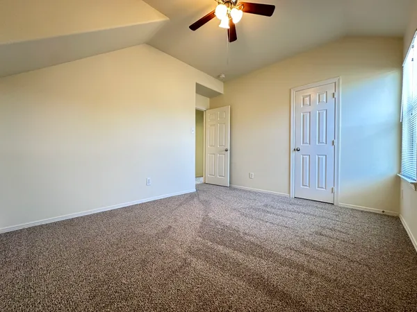 an empty room with chandelier fan