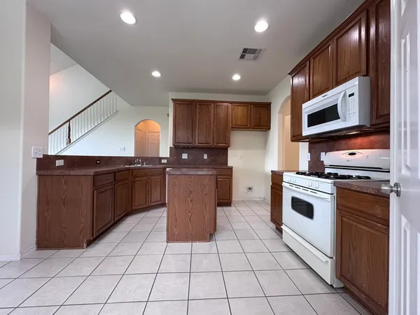 a kitchen with stainless steel appliances granite countertop a stove a sink and a microwave