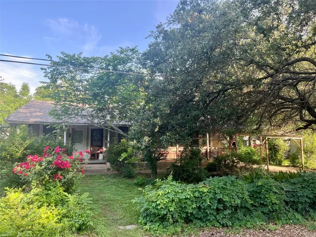 a front view of a house with yard and fountain
