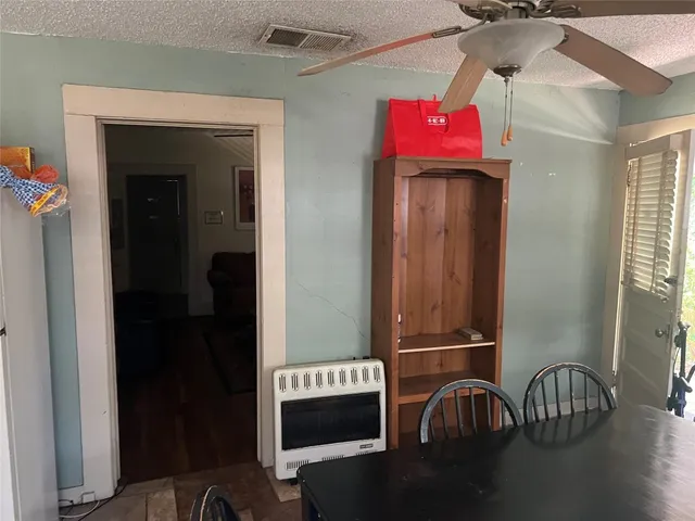a view of a hallway with wooden floor and a cabinet