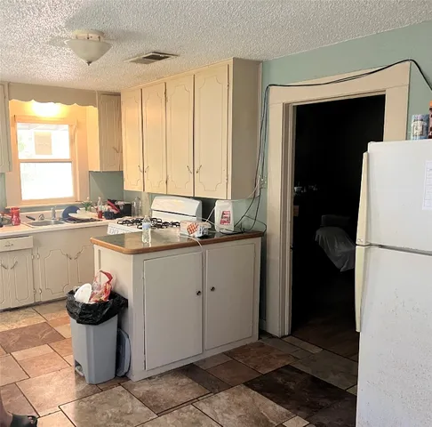 a kitchen with a refrigerator and a stove