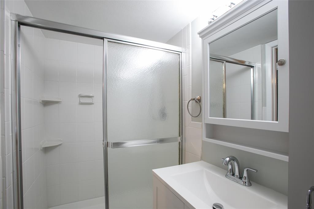 10557 Northwest 10th Street, Unit 101 Pembroke Pines, FL 33026 - Photo 11 of 19 a bathroom with a shower sink vanity and a mirror