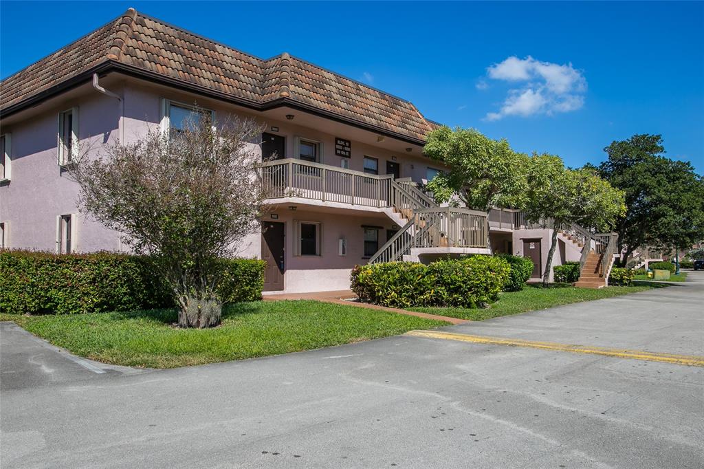 10557 Northwest 10th Street, Unit 101 Pembroke Pines, FL 33026 - Photo 15 of 19 a front view of a house with a garden