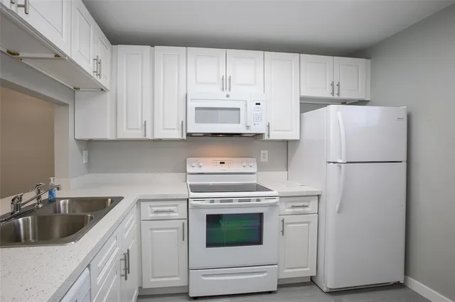 a kitchen with cabinets appliances and a sink