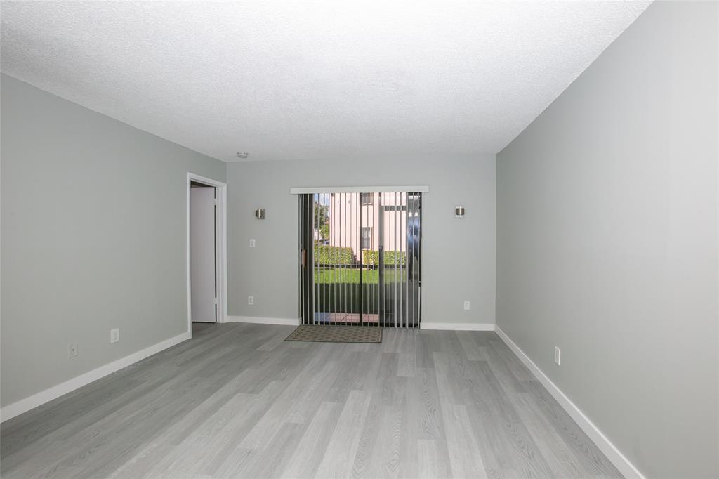 10557 Northwest 10th Street, Unit 101 Pembroke Pines, FL 33026 - Photo 4 of 19 wooden floor in an empty room with a window