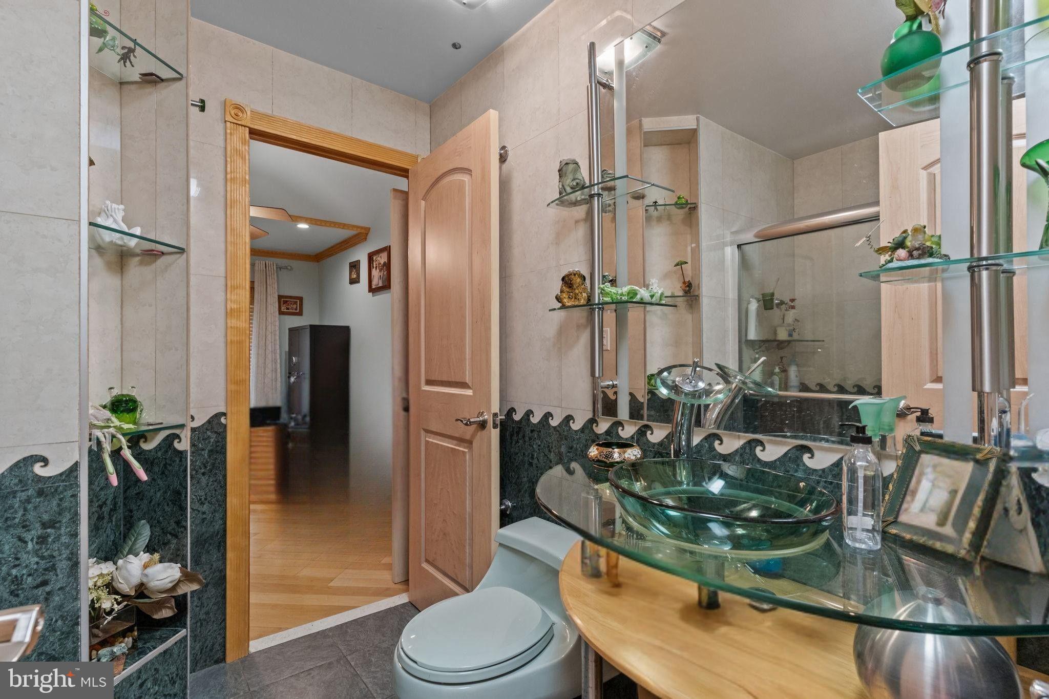 75 Bonnie Gellman Court, Unit D75 Philadelphia, PA 19114 - Photo 22 of 37 a bathroom with a granite countertop sink a toilet a mirror and shower