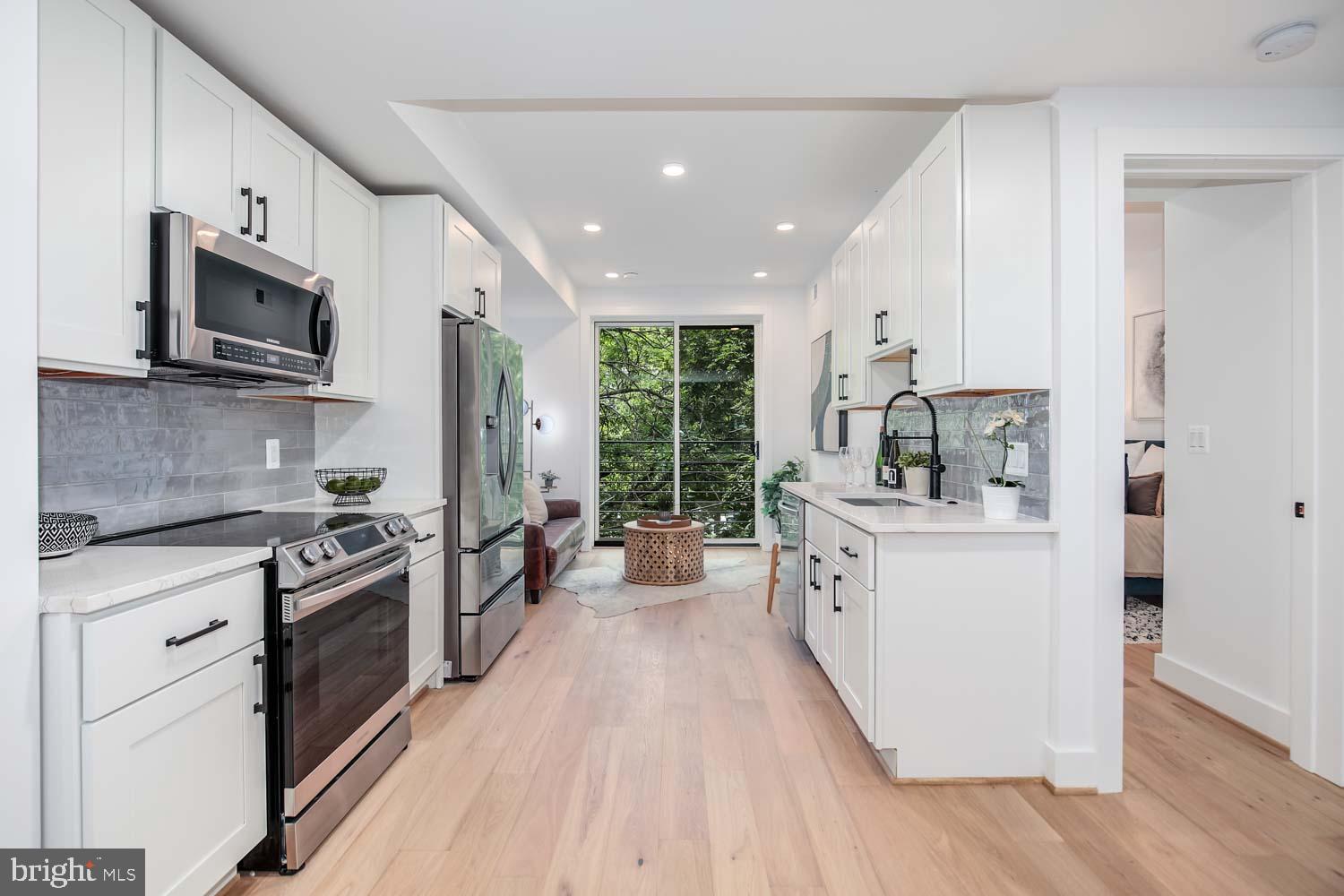 2601 30th Street Northeast, Unit 11 Washington, DC 20018 - Photo 1 of 32 a kitchen with stainless steel appliances a white cabinets and a stove top oven