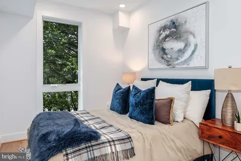 a bed room with a bed and a painting on the wall