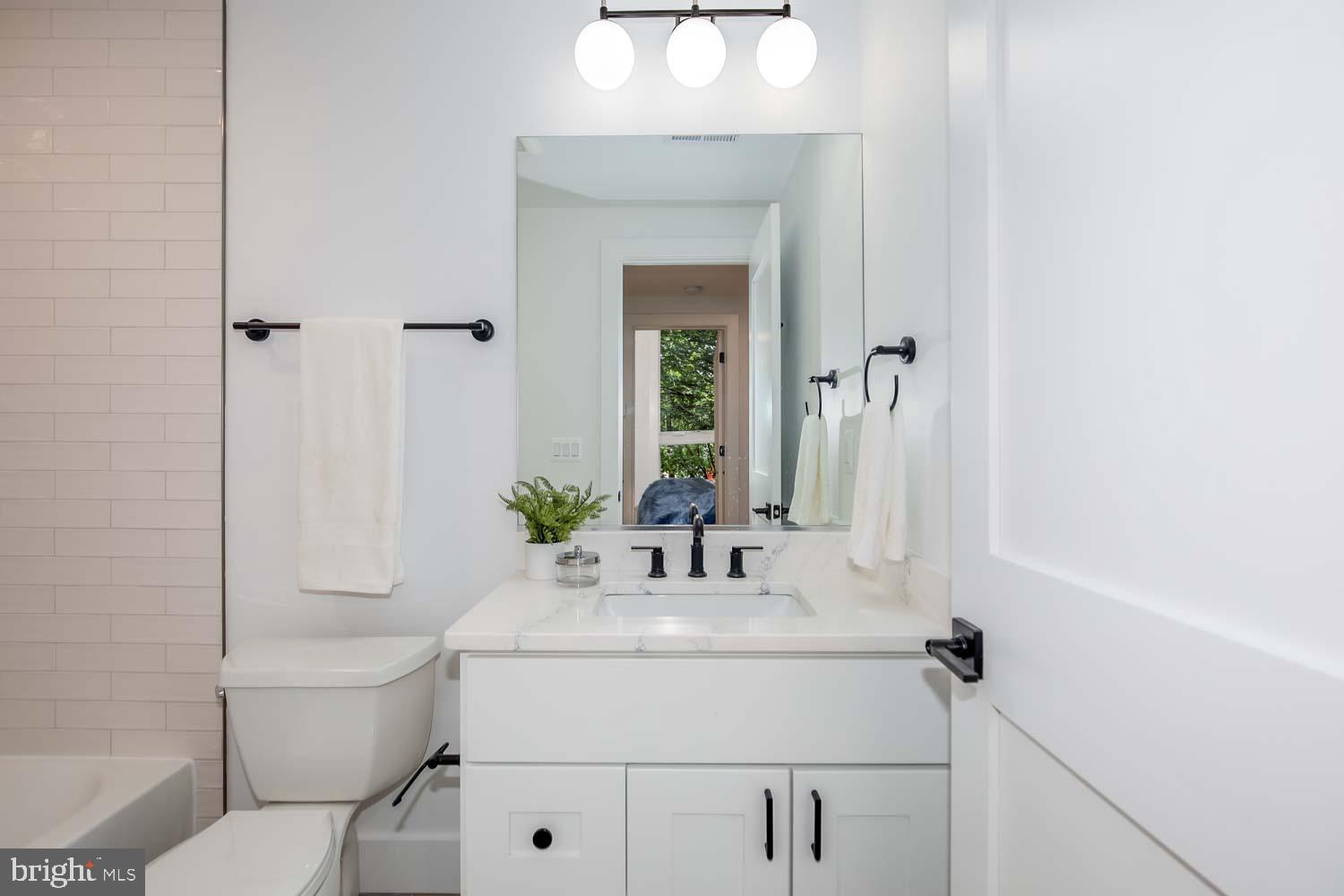2601 30th Street Northeast, Unit 11 Washington, DC 20018 - Photo 16 of 32 a bathroom with a sink a toilet and a mirror