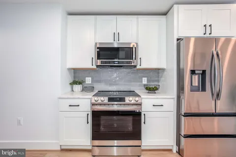 a kitchen with stainless steel appliances a stove microwave and refrigerator